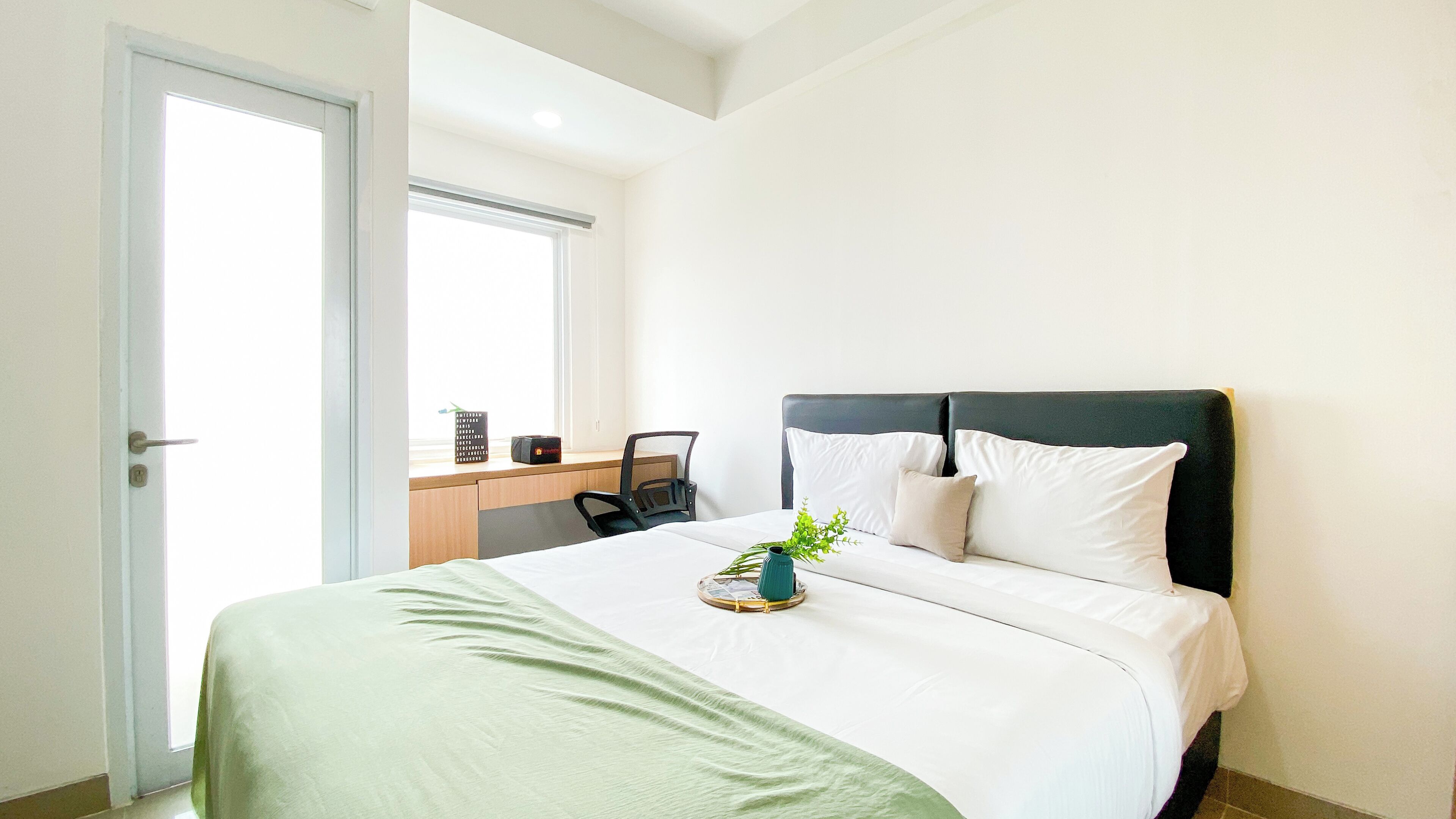 Een keurig opgeruimde hotelkamer met een bed, een bureau en een stoel.