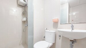 A modern bathroom with a toilet, a sink, and a shower. - Comfort And Homey 2Br At Podomoro City Deli Medan Apartment (Medan)