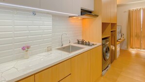 Eine moderne Küche mit integriertem Spülbecken, Holzschränken und einer Edelstahl-Dunstabzugshaube.
