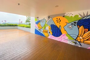 Experience the vibrant atmosphere of this open-plan space, featuring a lively mural and stunning views of the surrounding greenery and cityscape.