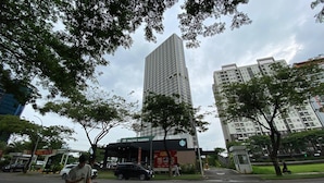 A tall building with a Starbucks sign, surrounded by trees and other buildings.