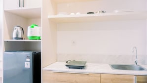 A kitchen with a refrigerator, a kettle, a scale, and a sink. - Comfort And Cozy Stay Studio Collins Boulevard Apartment (Tangerang)