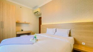 Habitación de hotel con una cama grande, cabecera de madera, mesita de noche, armario y aire acondicionado de pared.