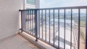 A balcony with a metal railing overlooking a cityscape. - Modern Look 1Br Without Living Room At Bintaro Embarcadero Apartment (South Tangerang)