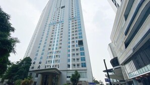 A tall, modern building with a prominent entrance and multiple floors.