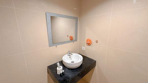 A bathroom with a white sink, a mirror, and two soap dispensers. - Comfortable Living And Best Location 1Br At Grand Sungkono Lagoon Apartment (Surabaya)