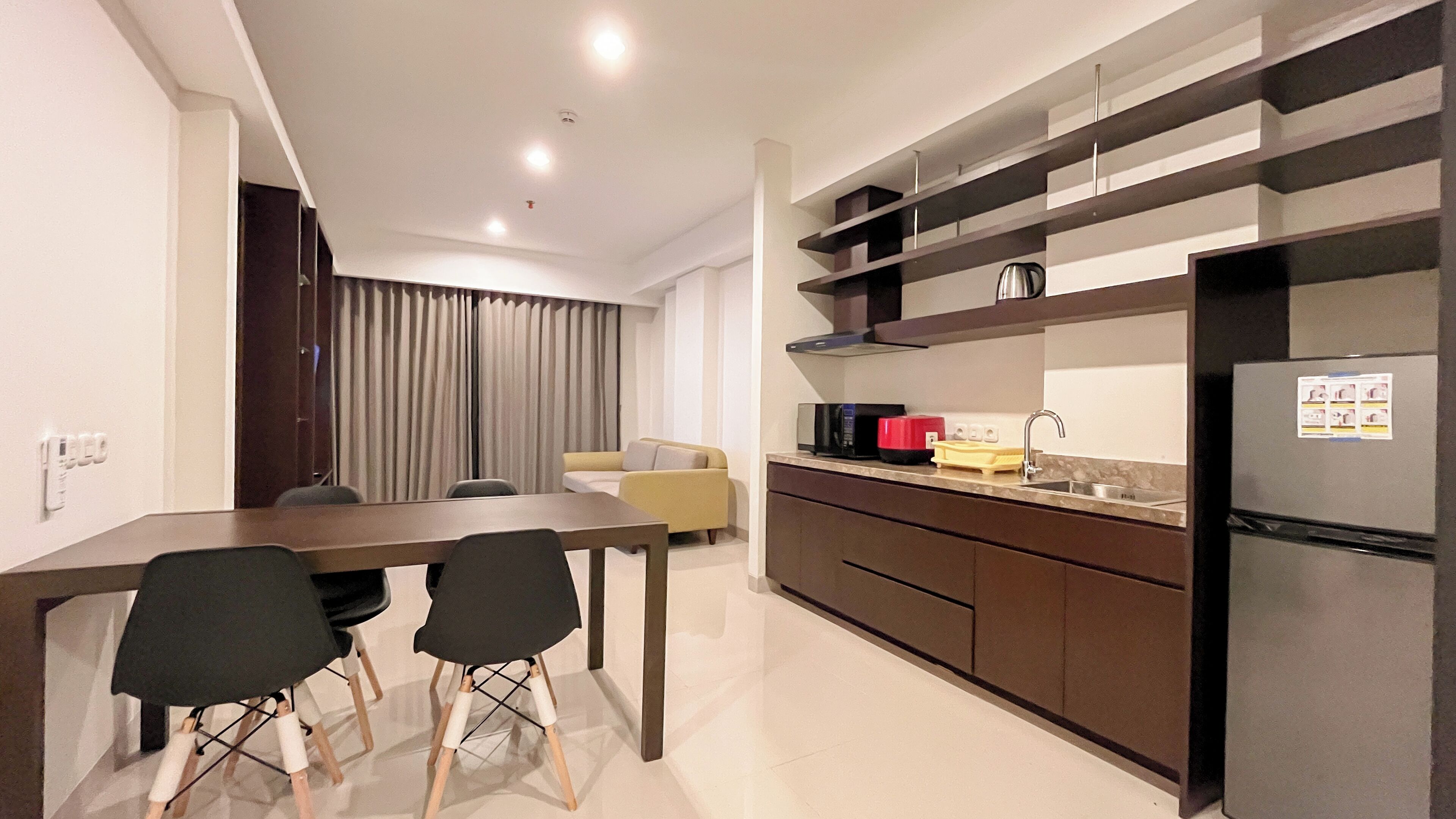 Una cocina moderna con comedor, que incluye una mesa, sillas, un sofá y un refrigerador.