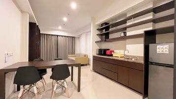 Una cocina moderna con comedor, que incluye una mesa, sillas, un sofá y un refrigerador.