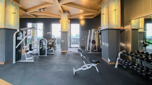 Una palestra con diverse attrezzature per l'allenamento, tra cui panche, manubri e macchinari per pesi.
