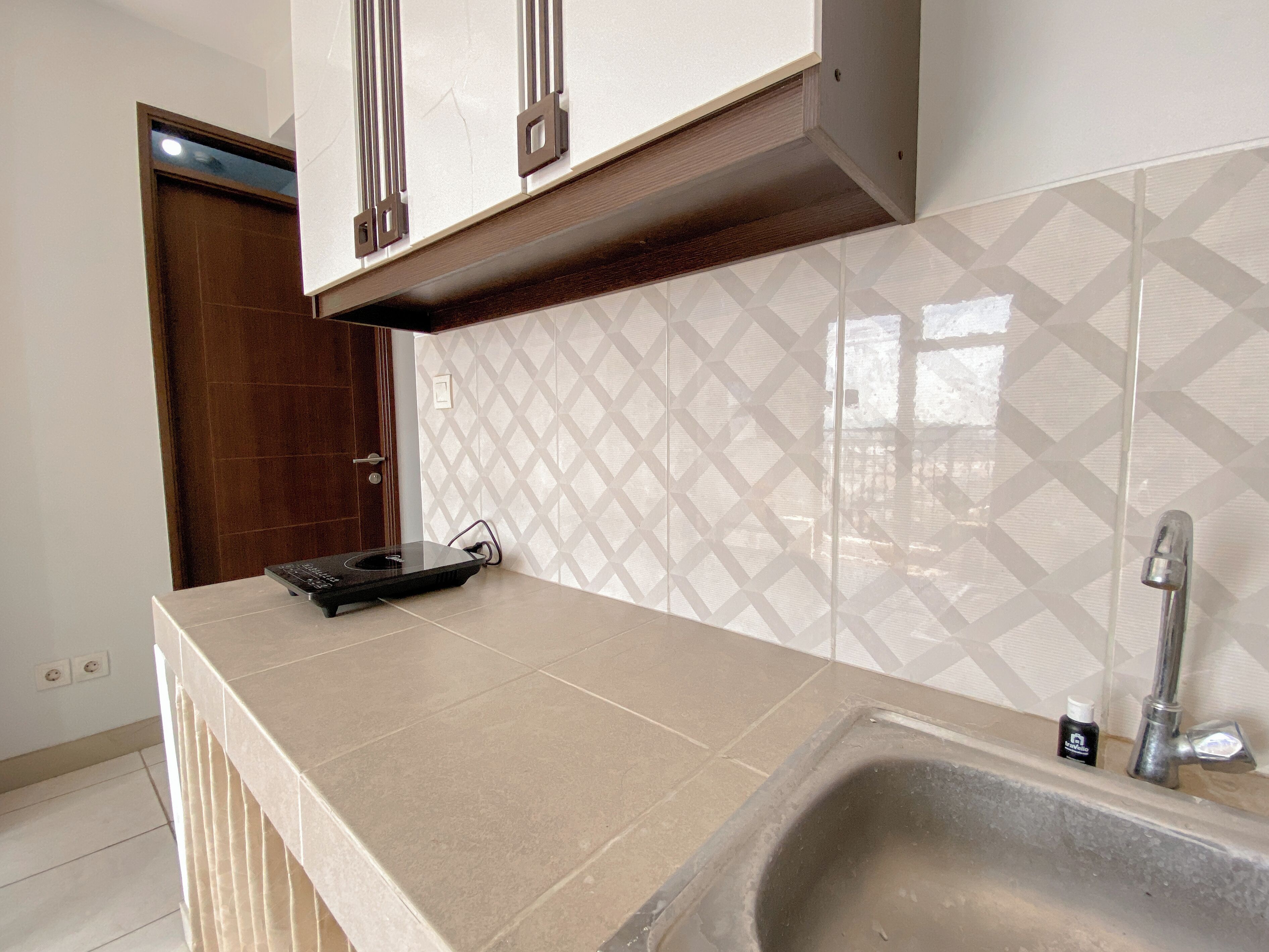 Keittiössä on laatoitettu seinäosa tiskialtaan yläpuolella, tiskiallas ja työtaso.