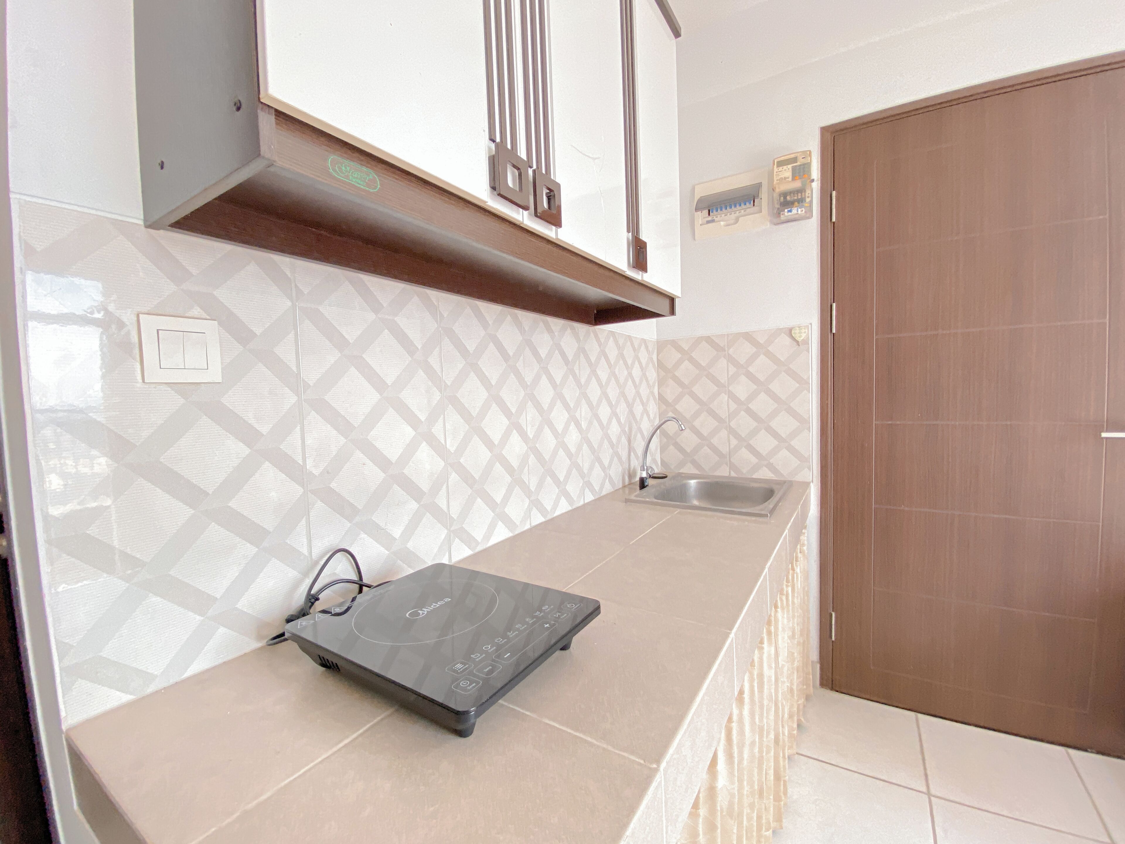 A kitchen with a countertop, a sink, and a door.