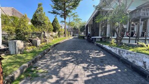 A paved pathway flanked by greenery and buildings. - Stylish Studio (No Kitchen) Apartment At Skales Residence Nusa Dua Bali (Nusa Dua)