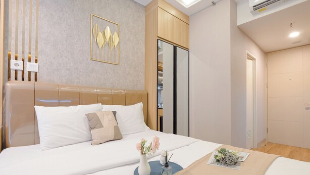Une chambre d’hôtel moderne, dotée d’un grand lit, d’une armoire et d’un élément décoratif mural.