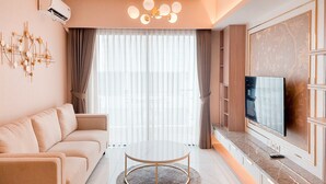 Ein modernes Wohnzimmer mit einer Couch, einem runden Couchtisch, einem Flachbildfernseher und einer Wanddekoration.