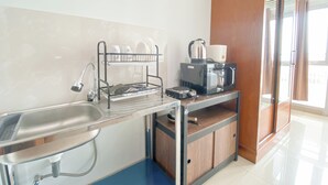 Eine kleine Küche mit Spüle, Geschirrständer, Mikrowelle und Kaffeemaschine.