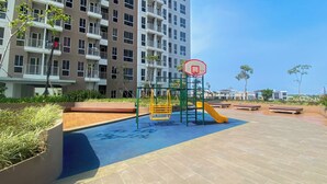 Un'area giochi con canestro da basket, scivoli e panchine.