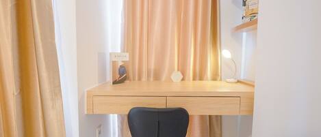 A study area with a desk, chair, and a lamp.