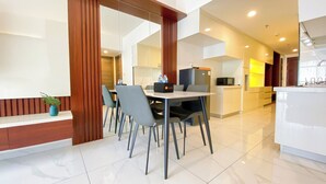 Una habitación de hotel moderna con comedor, cocina y baño.