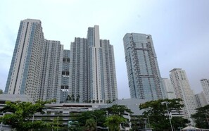 A high-rise building with a modern architectural design, featuring multiple balconies and a glass facade. - Minimalist 2Br And Well Design Room At Benson Supermall Mansion Apartment (Surabaya)