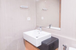 A modern bathroom with a white sink, black countertop, and a large mirror. - Elegant 1Br Without Living Room Apartment Bintaro Embarcadero (South Tangerang)