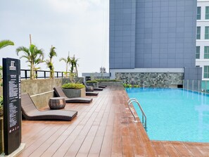 Relax by the pool surrounded by lush greenery and enjoy the tranquil atmosphere.