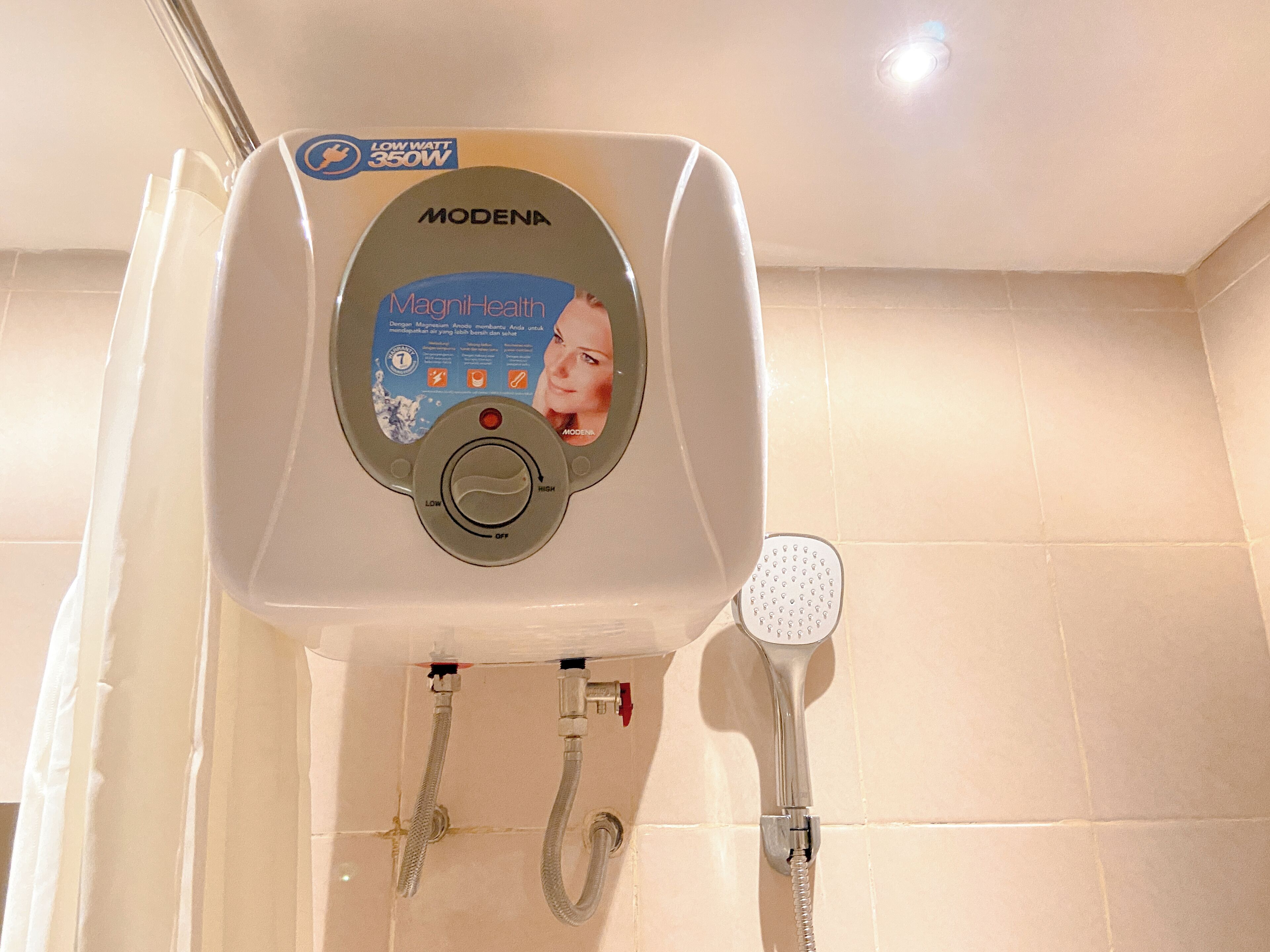 A low wattage showerhead with a control panel labeled "MagnitHealth" and "MODENA" on a bathroom wall.