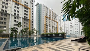 A swimming pool with tiled deck, surrounded by tall residential buildings. - Good Deal And Comfy 1Br Apartment At Paramount Skyline (Gading Serpong)