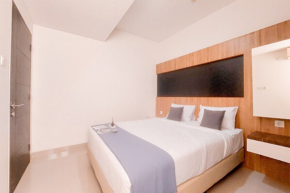 Une chambre moderne avec un grand lit, une tête de lit en bois, une table de chevet et une armoire intégrée.