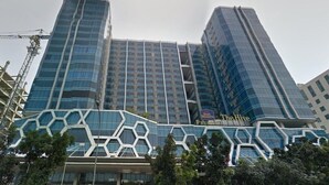 A hotel with a modern glass facade and a distinctive geometric pattern on the lower level. - Great City View Studio At Tamansari The Hive Apartment (Jakarta)