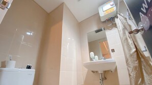 A bathroom with a toilet, sink, and shower curtain. - Best Deal 1Br Apartment Parahyangan Residence (Bandung)
