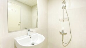 Bathroom features a sink, handheld showerhead, and large mirror.