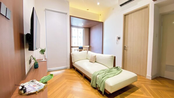 Relax in this stylish room with a comfortable sofa, a small table, and a door leading to another space.
