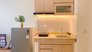 Une cuisine compacte avec des meubles en bois, un four encastré et un évier en acier inoxydable.