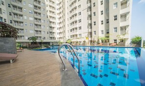 Enjoy a refreshing swim from the rooftop pool surrounded by a deck and lush greenery.