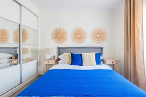 Una habitación de hotel moderna con una cama grande, un espejo y decoración en la pared.