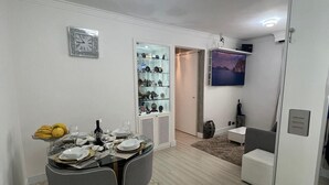 A modern dining area with a glass table, chairs, and a decorative clock on the wall. - Amazonas/IBC/PCD/Congonhas Airport/Interlagos Racetrack/Expo Transamerica. (Campo Grande)