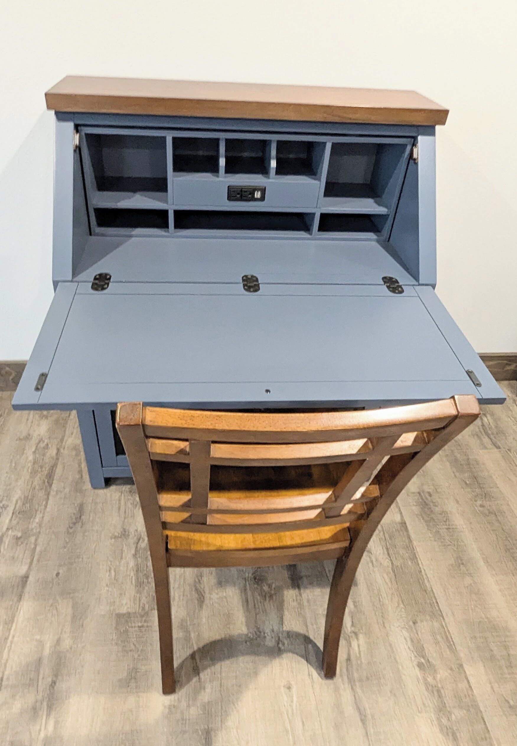 Un bureau compact et pliable, doté d’un plateau en bois et d’une chaise avec une structure et un siège en bois.