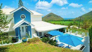 Ein Haus mit Pool, einer überdachten Terrasse und Blick auf die Hügel.