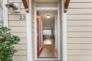 Un couloir étroit avec une porte en bois, une plaque portant le numéro « 22 » et une petite fenêtre au fond.