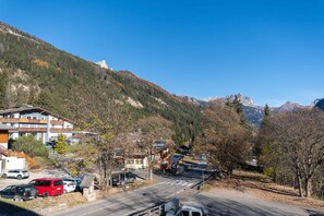 Eine Bergstadt mit einer Straße, die zu einem mehrstöckigen Gebäude mit Balkonen führt.