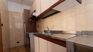 Een moderne keuken met een roestvrijstalen spoelbak, houten kastjes en een ingebouwde oven.