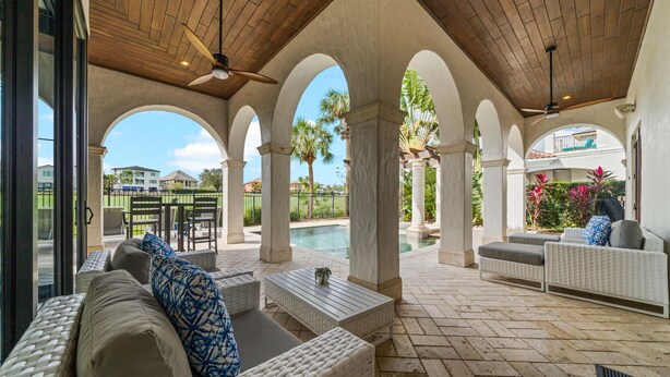 An outdoor patio area with a pool, covered seating, and a view of the surrounding neighborhood. - 5BR Luxury Villa • Games & Golf • Near Disney (Reunion)