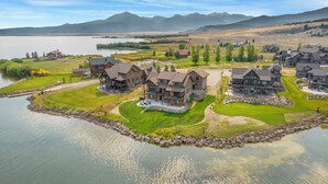 Un barrio residencial junto al lago con varias casas, un muelle y un césped bien cuidado.