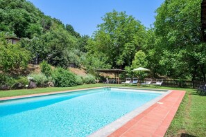 Una piscina al aire libre de temporada, sombrillas