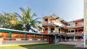 Un hôtel à plusieurs étages, doté de balcons, d’une cour intérieure et d’une enseigne publicitaire indiquant « Villas del Plan Hotel ».