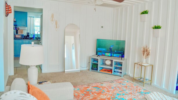 A living room with a television, a ceiling fan, a sofa, and a rug. - Bright & Cozy, Walk To Downtown, 3.5 Miles to Stadium.Grill, LightUp Vanity&Crib (Austin)