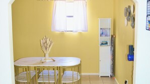 A dining area with a round table and chairs, a window with curtains, a white cabinet, and a blue water dispenser. - Bright & Cozy, Walk To Downtown, 3.5 Miles to Stadium.Grill, LightUp Vanity&Crib (Austin)