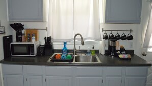 A kitchen with a microwave, toaster, sink, and various utensils. - Bright & Cozy, Walk To Downtown, 3.5 Miles to Stadium.Grill, LightUp Vanity&Crib (Austin)