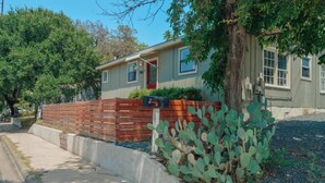 A residential house with a mailbox, a wooden fence, and a cactus plant in the front yard. - Bright & Cozy, Walk To Downtown, 3.5 Miles to Stadium.Grill, LightUp Vanity&Crib (Austin)