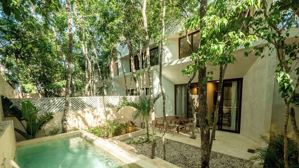 A modern outdoor pool area with a dining table and chairs, surrounded by trees and plants. - Jungle & Relax: Private Pool- Garden Wifi  (Tulum)